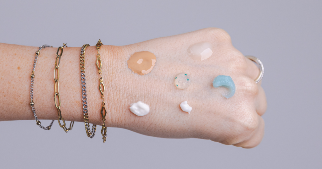 Assorted skincare products displayed on the back of a woman’s hand.